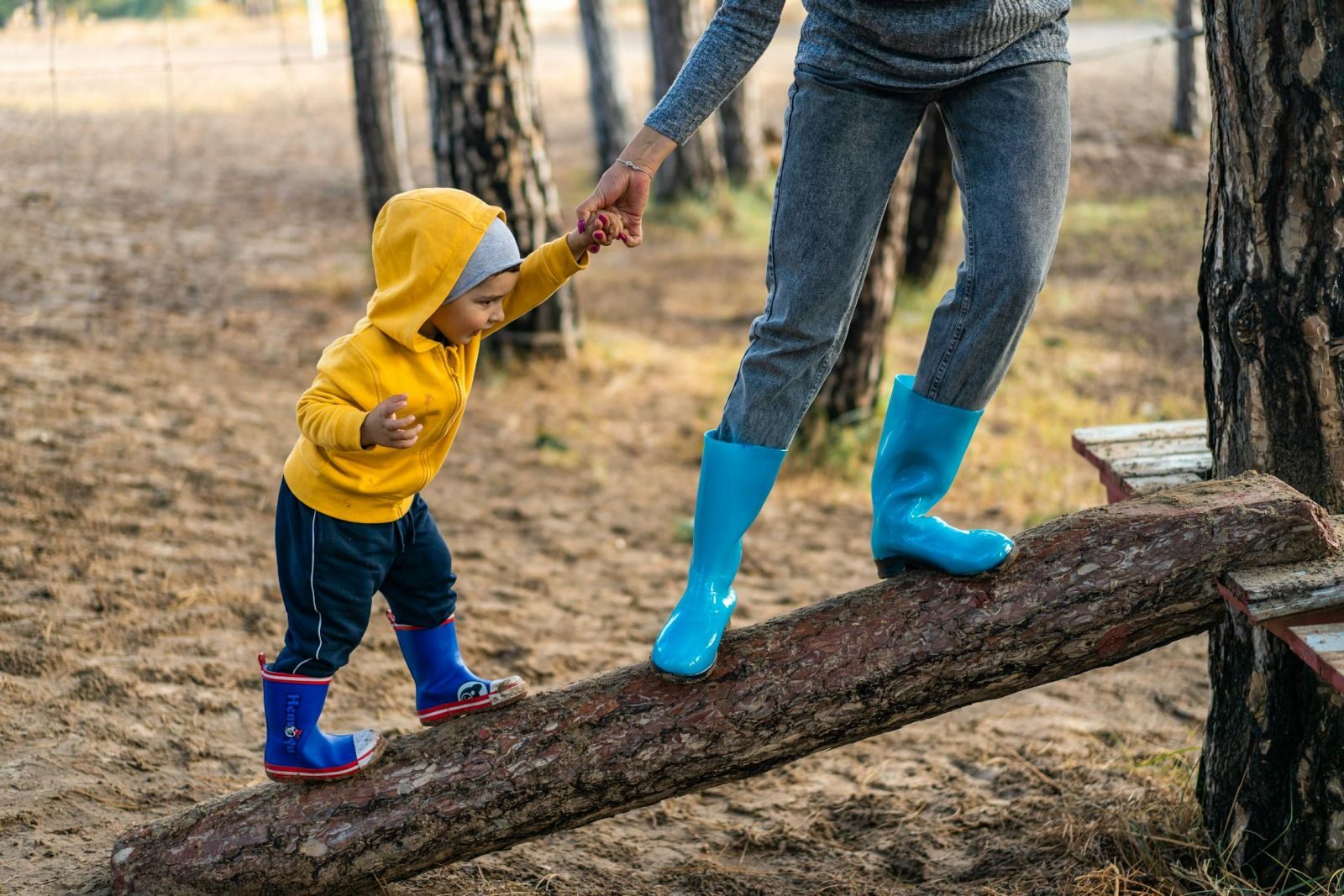 Woman holding son's hand climbing on a tree